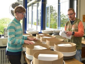 Two workshop employees pack pottery wheels